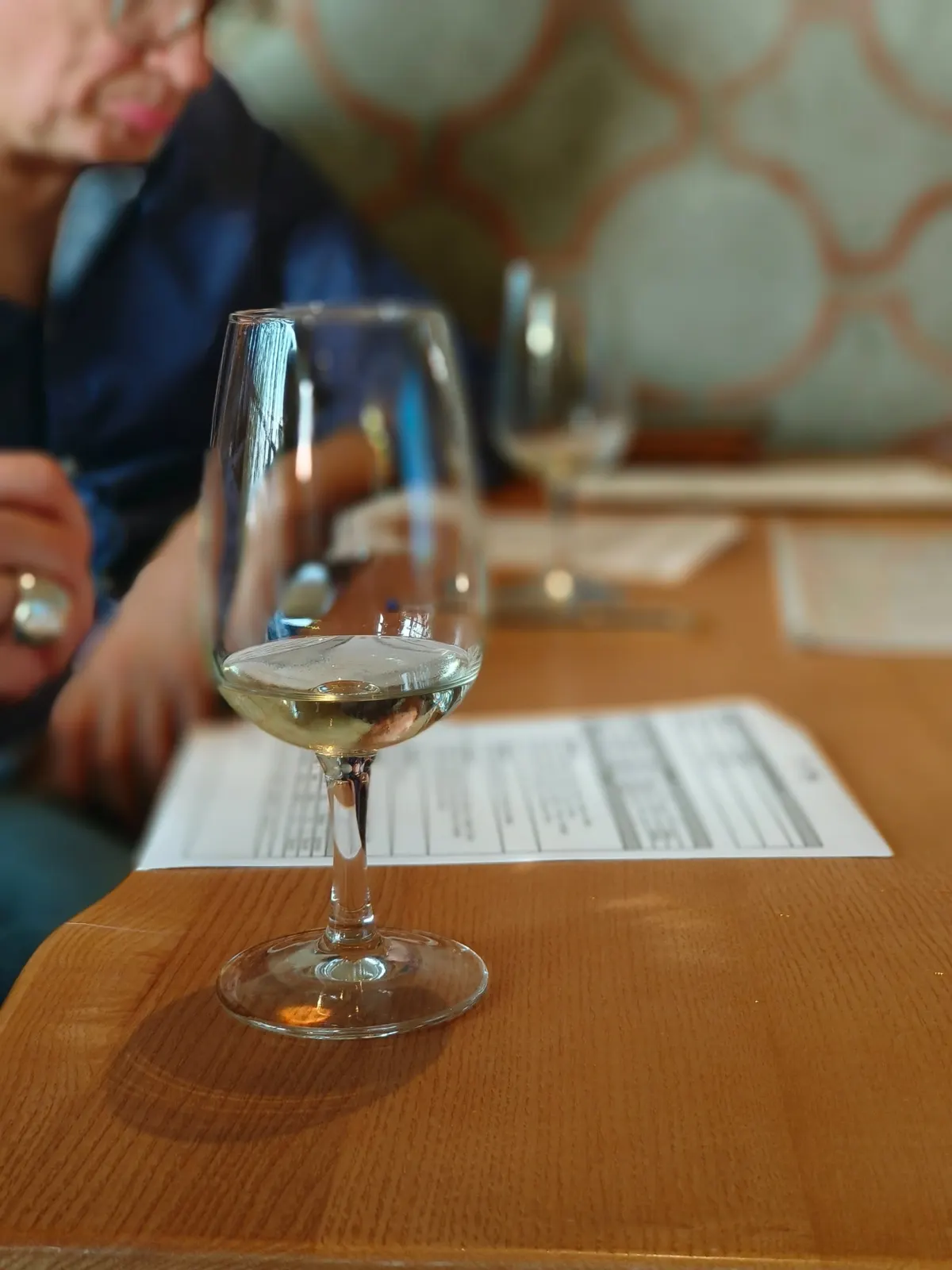 Verre de vin blanc et fiche de dégustation pendant un atelier Revinsy